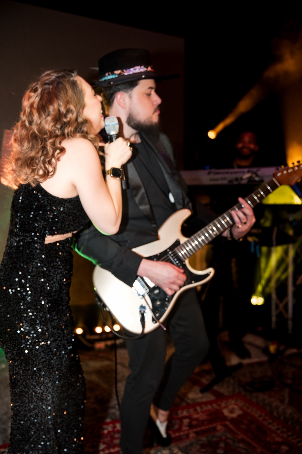 Tori and Will performing side by side, with vocals and electric guitar